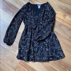 Black midi dress with long sheer sleeves.